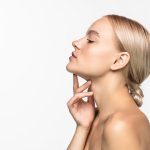 Mujer joven de perfil mostrando el rostro con orgullo porque no aparecen arrugas