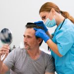 Hombre tras recibir tratamiento de mesoterapia capilar ver los resultados de la eficacia del tratamiento en un espejo de mano